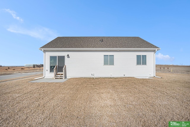 back of property featuring a yard and a rural view