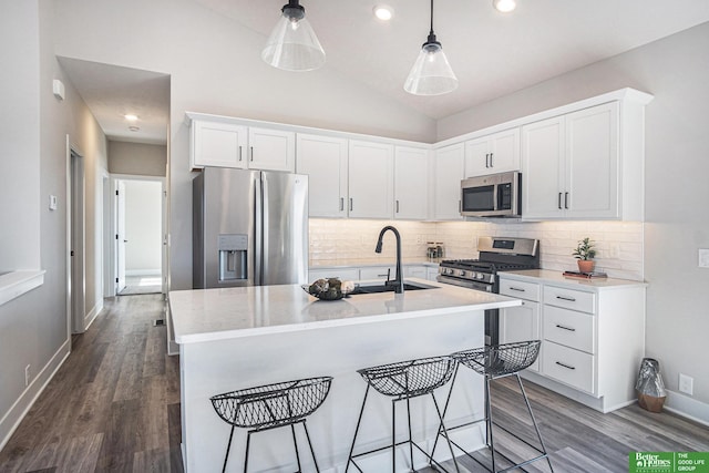 kitchen featuring stainless steel appliances, an island with sink, sink, and white cabinets