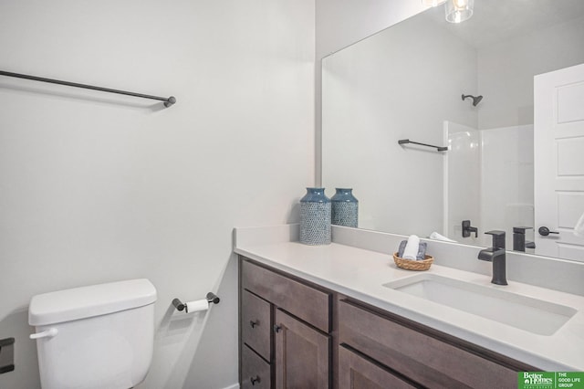 bathroom featuring vanity, toilet, and walk in shower