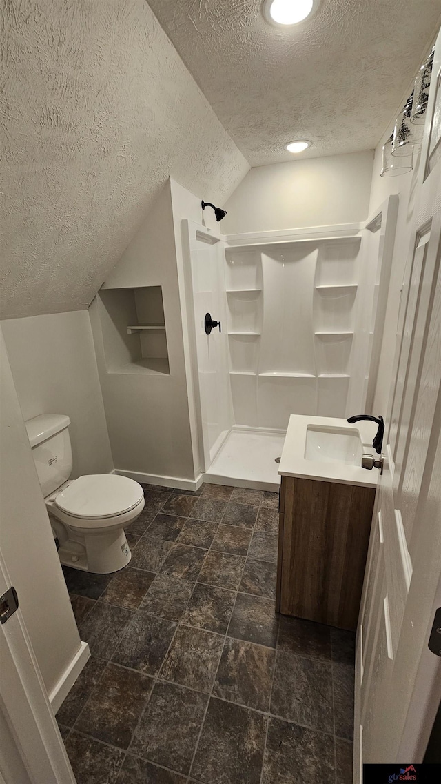 bathroom with a shower, lofted ceiling, vanity, toilet, and a textured ceiling