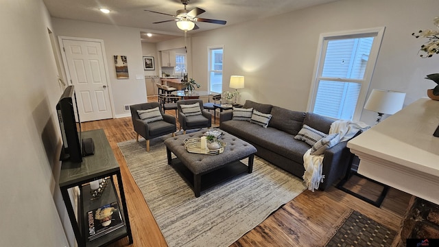 living room featuring ceiling fan, hardwood / wood-style floors, and a wealth of natural light