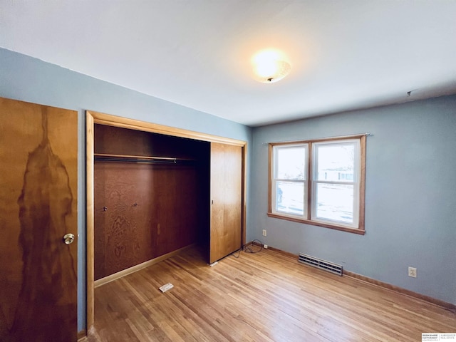 unfurnished bedroom with hardwood / wood-style flooring and a closet