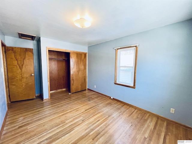 unfurnished bedroom featuring a closet and light wood-type flooring