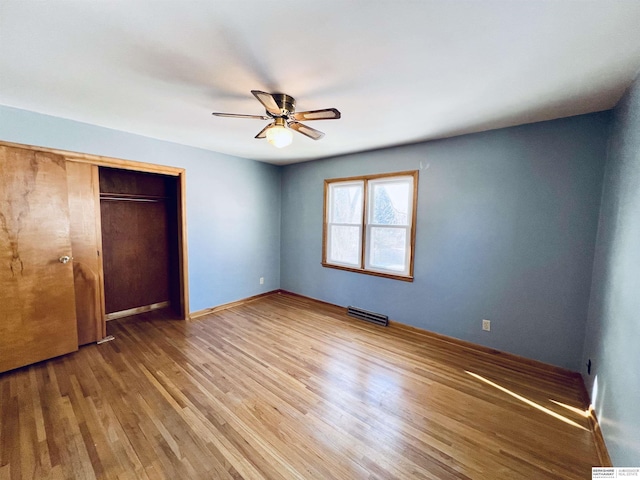 unfurnished bedroom with hardwood / wood-style flooring, ceiling fan, and a closet