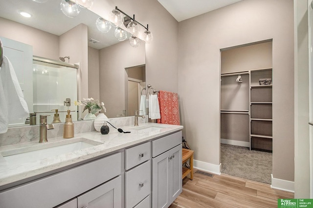 bathroom with wood-type flooring, an enclosed shower, and vanity