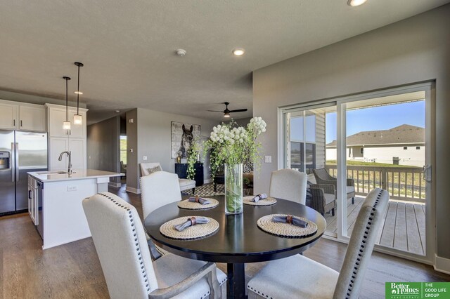 dining space featuring hardwood / wood-style flooring, sink, and ceiling fan