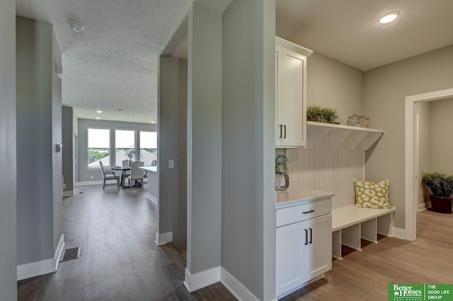 mudroom featuring light hardwood / wood-style flooring and a textured ceiling