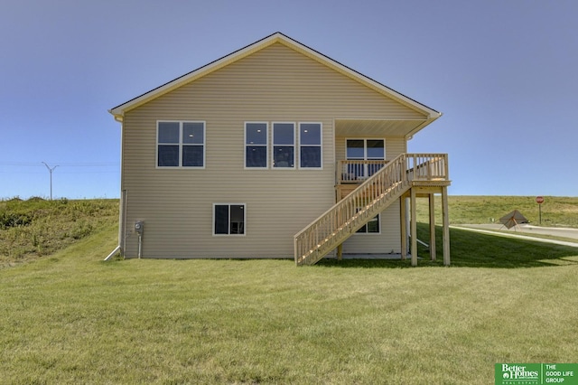 rear view of property with a wooden deck and a lawn