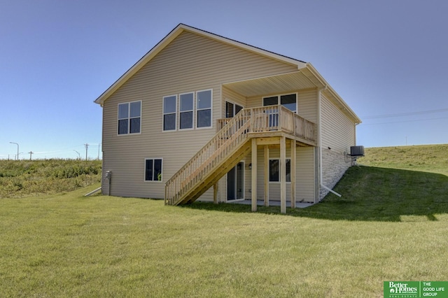 rear view of house with a wooden deck, central air condition unit, and a lawn