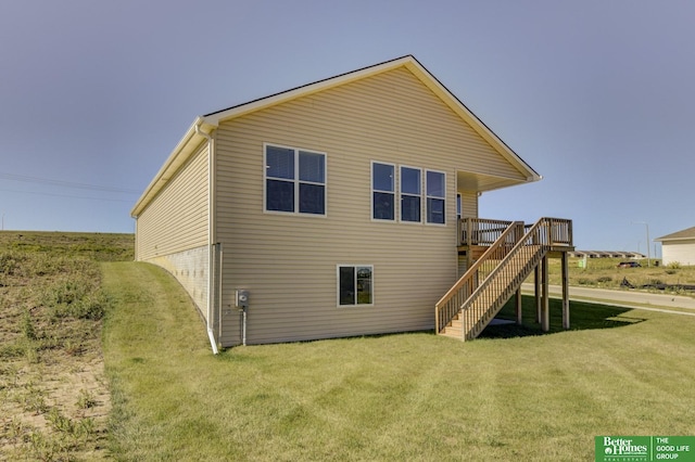 back of property with a wooden deck and a lawn