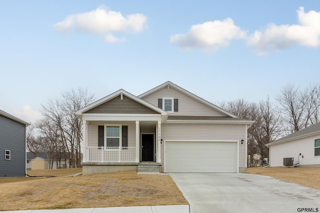 view of front of house with a porch, a garage, a front lawn, and central air condition unit