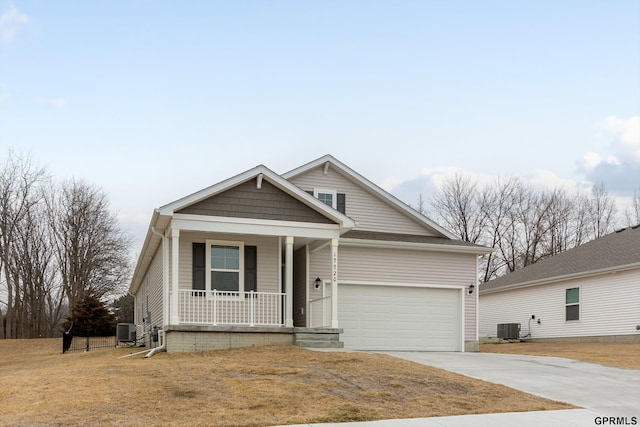 view of front of home featuring a porch, a garage, central AC, and a front yard