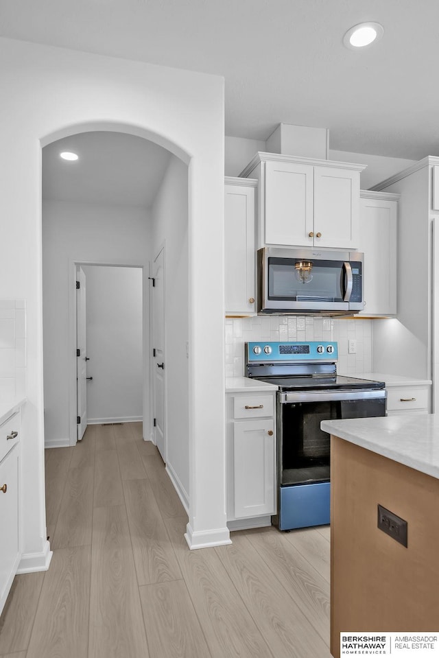 kitchen featuring white cabinetry, stainless steel appliances, and light hardwood / wood-style floors