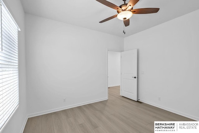 spare room featuring ceiling fan, plenty of natural light, and light wood-type flooring