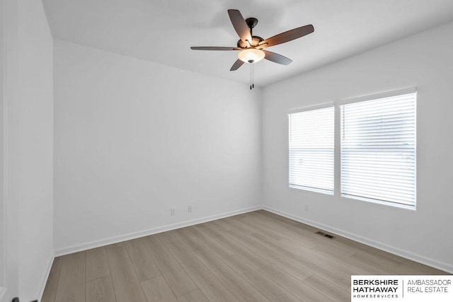 empty room with ceiling fan and light hardwood / wood-style floors