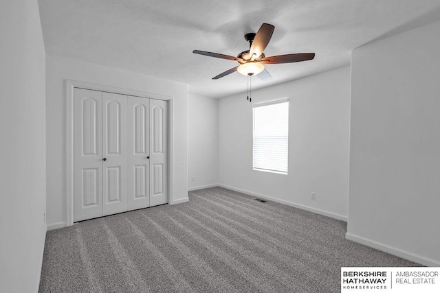 unfurnished bedroom featuring carpet, ceiling fan, and a closet