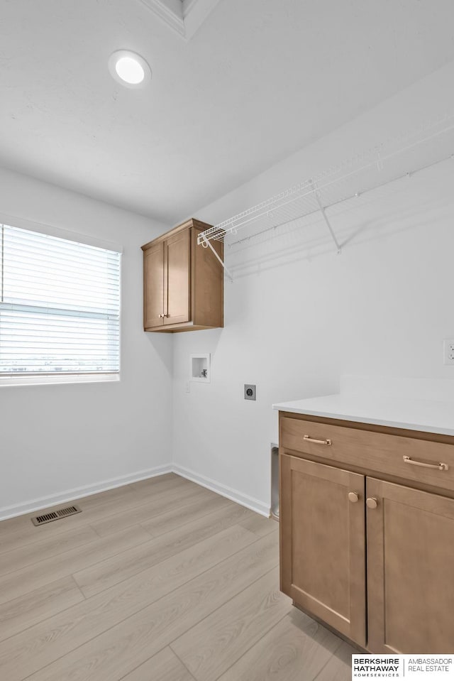 laundry room with cabinets, washer hookup, hookup for an electric dryer, and light hardwood / wood-style flooring