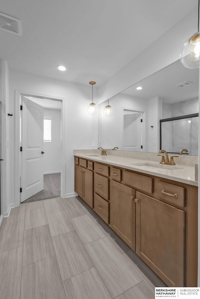 bathroom with vanity and a shower with door