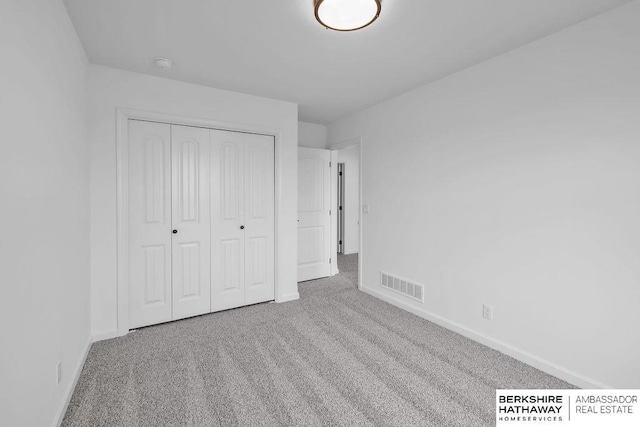 unfurnished bedroom featuring carpet flooring and a closet