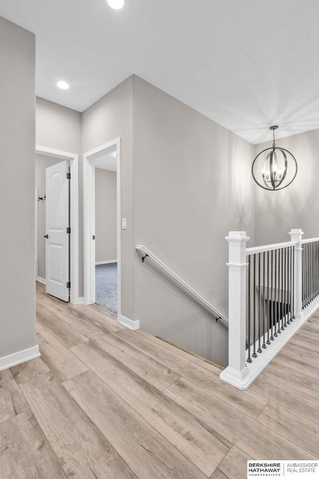 stairway with a chandelier and hardwood / wood-style floors