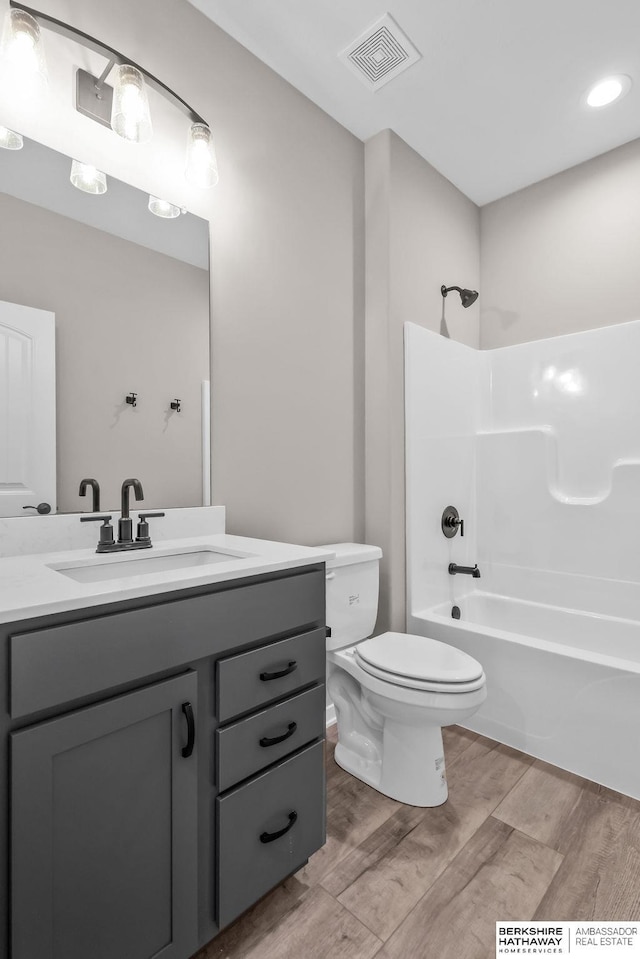 full bathroom with vanity, toilet, hardwood / wood-style floors, and shower / bathing tub combination