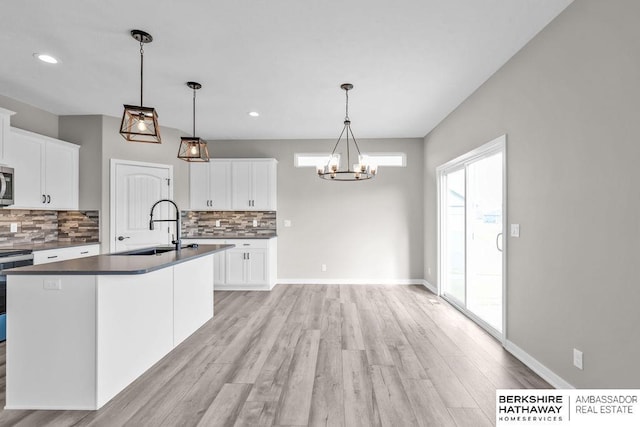 kitchen with pendant lighting, sink, a healthy amount of sunlight, and white cabinets