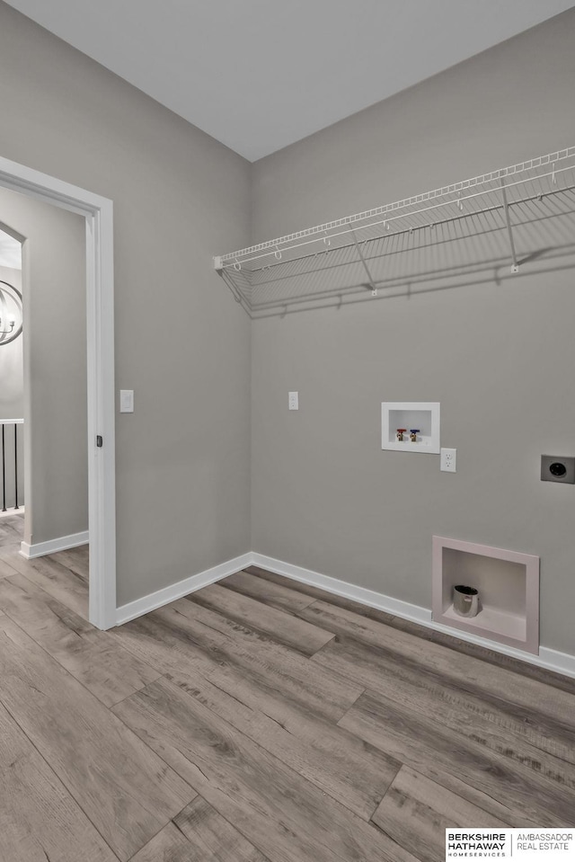 clothes washing area with hookup for an electric dryer, light hardwood / wood-style floors, and hookup for a washing machine