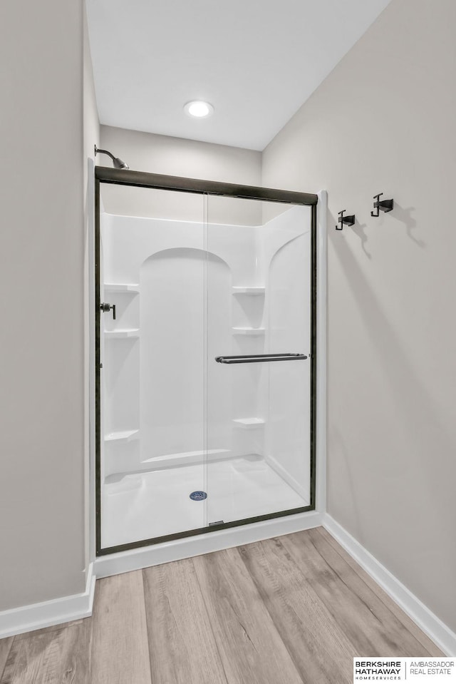 bathroom with hardwood / wood-style flooring and an enclosed shower