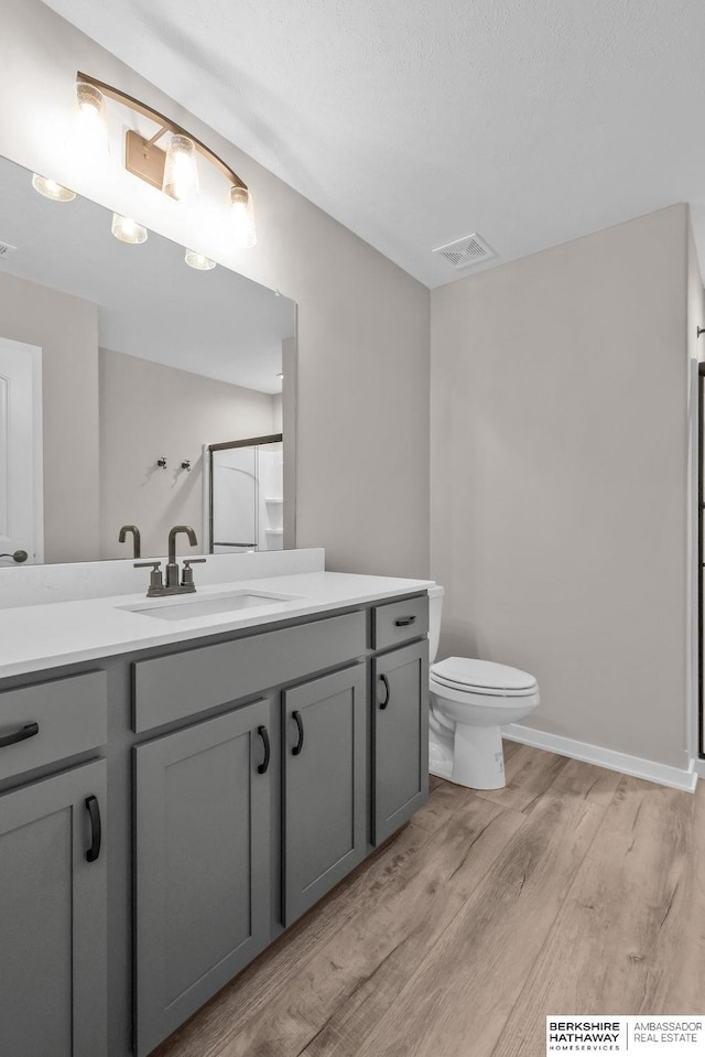 bathroom with hardwood / wood-style flooring, vanity, and toilet