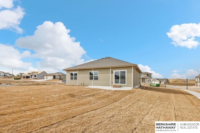 rear view of house featuring a patio and a yard