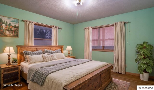 bedroom featuring dark hardwood / wood-style flooring and a textured ceiling