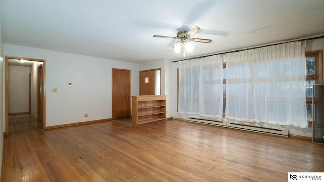 empty room with hardwood / wood-style flooring, ceiling fan, and baseboard heating