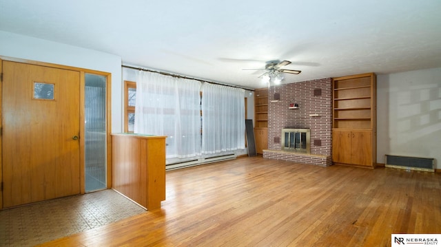 unfurnished living room with light hardwood / wood-style flooring, built in features, ceiling fan, baseboard heating, and a brick fireplace