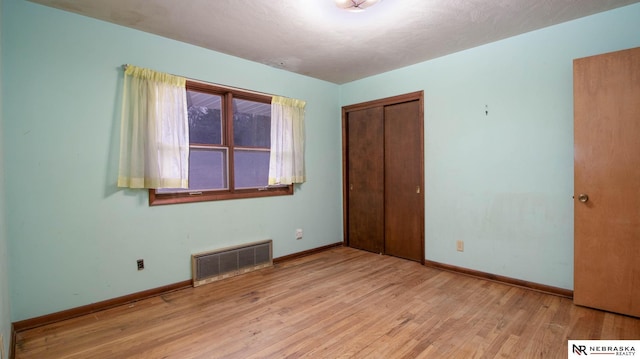 unfurnished bedroom with light hardwood / wood-style floors and a closet