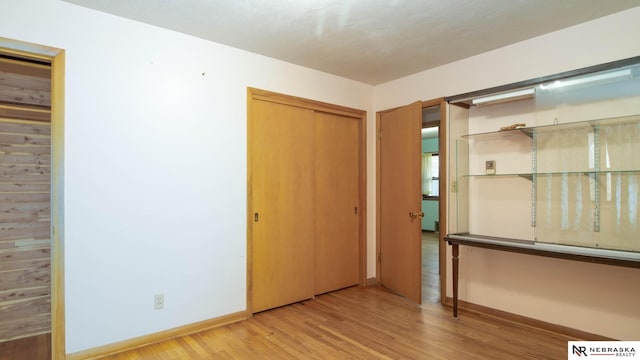 unfurnished bedroom featuring wood-type flooring and a closet