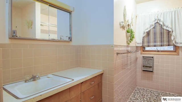 bathroom featuring vanity and tile walls