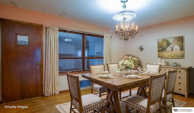 dining space featuring a notable chandelier and light hardwood / wood-style flooring