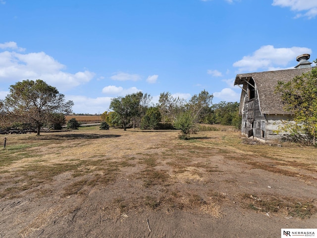 view of yard featuring a rural view and an outdoor structure