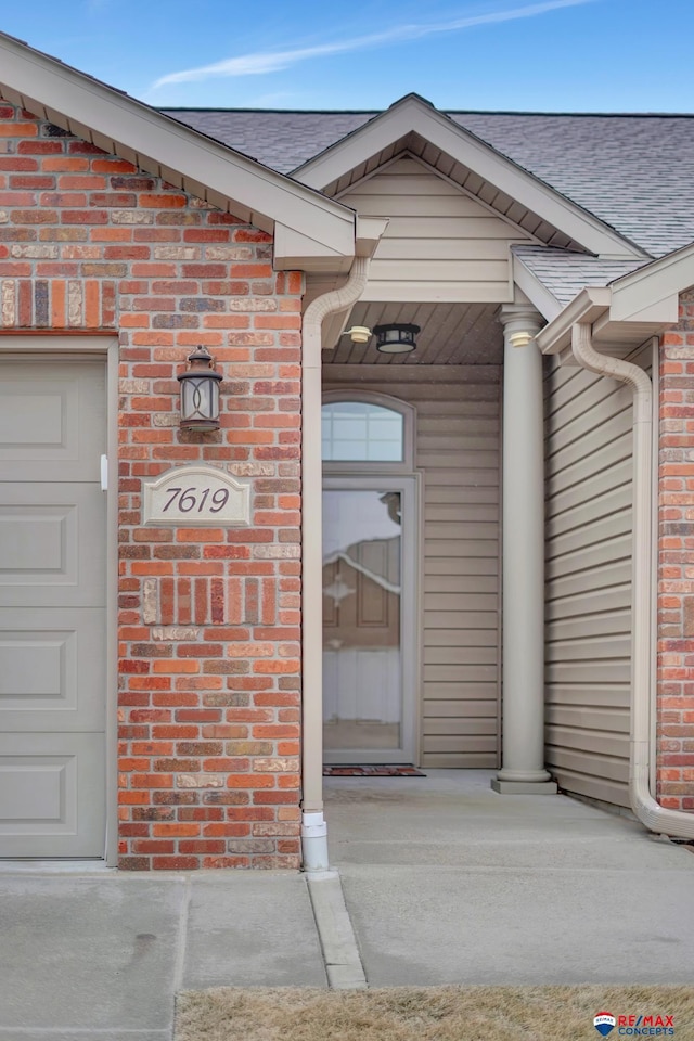 view of exterior entry with a garage and covered porch