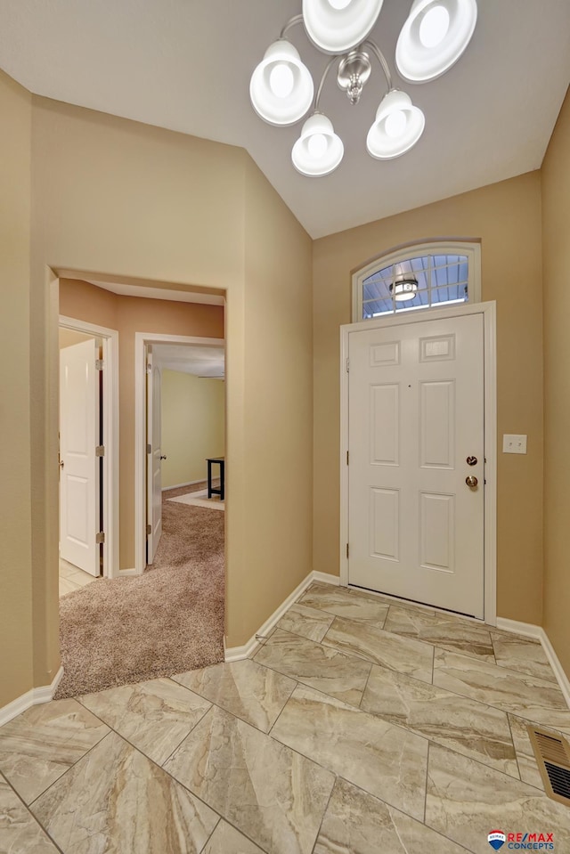 entrance foyer with lofted ceiling and a chandelier