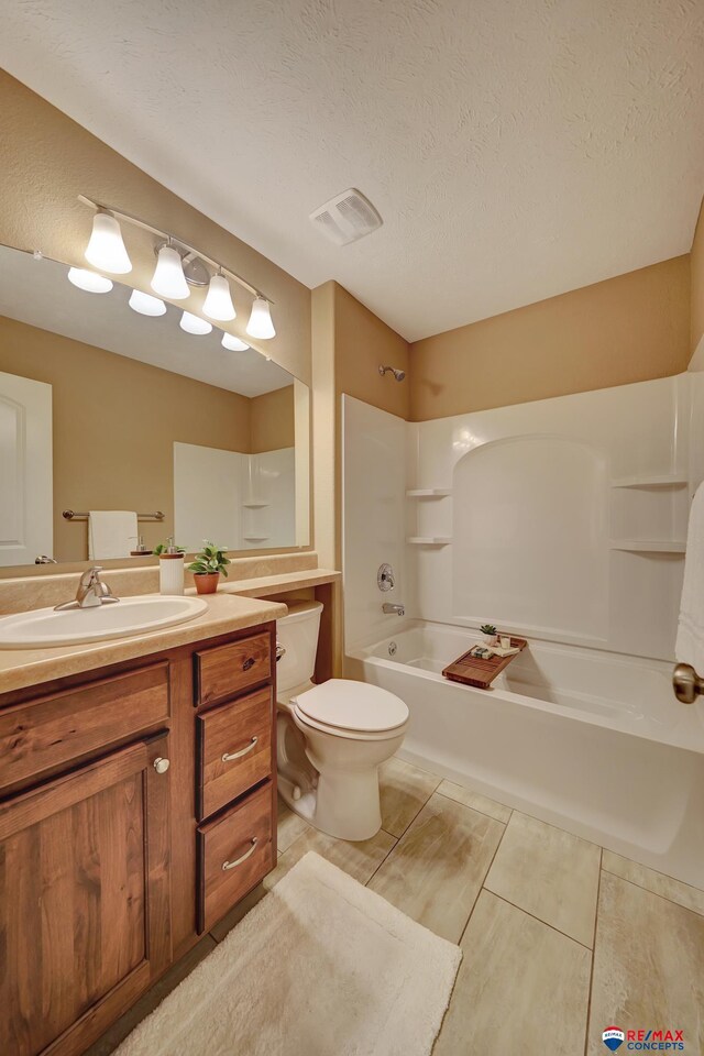 full bathroom featuring vanity, shower / tub combination, toilet, and a textured ceiling