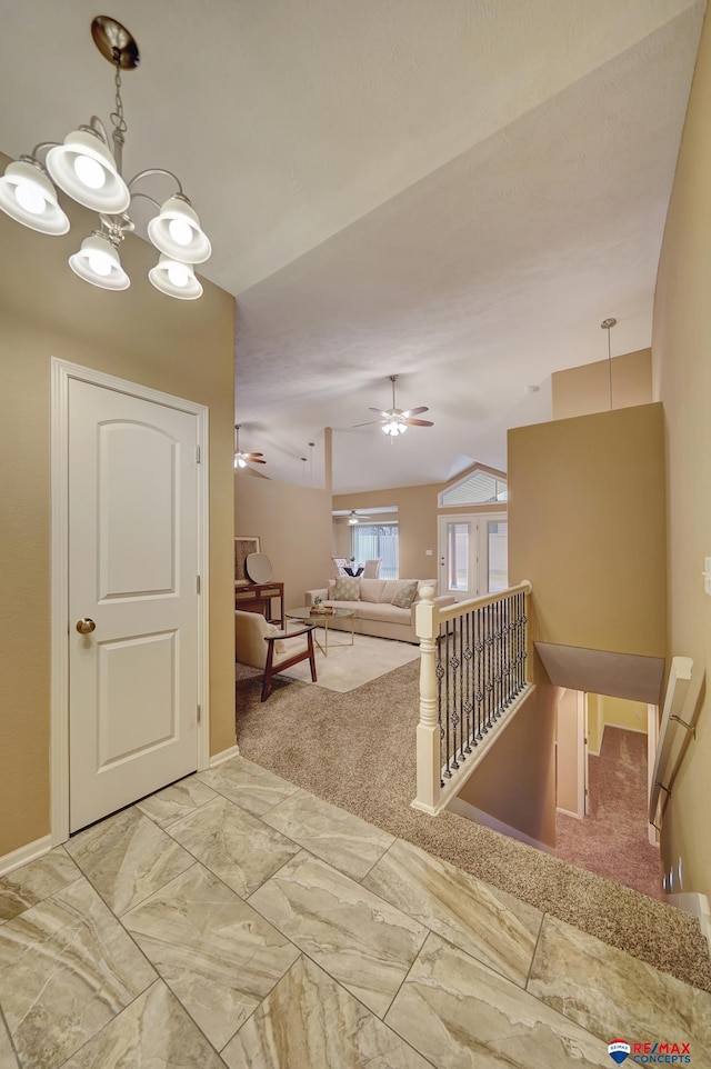 corridor featuring an inviting chandelier, carpet flooring, and vaulted ceiling