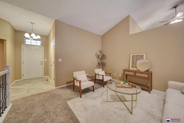 carpeted foyer featuring lofted ceiling and ceiling fan with notable chandelier