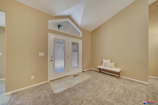 carpeted foyer entrance featuring lofted ceiling