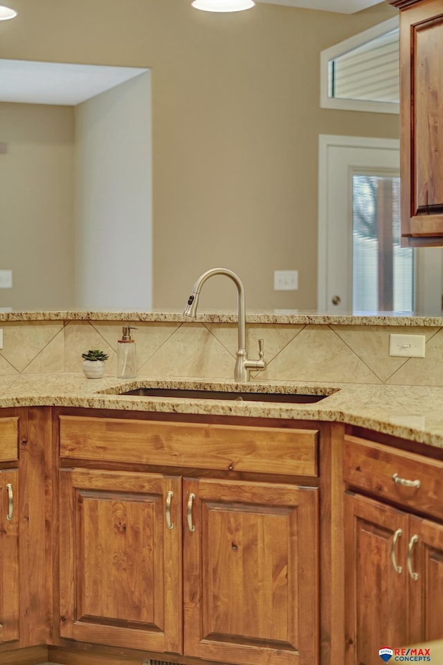 kitchen with light stone countertops and sink