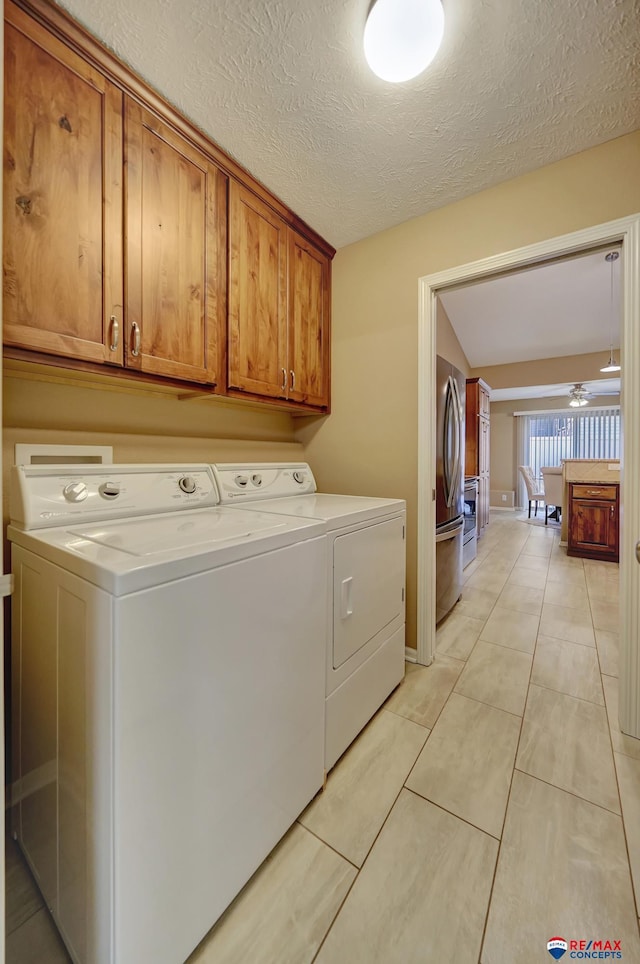 laundry area featuring light tile patterned flooring, cabinets, washer and dryer, a textured ceiling, and ceiling fan