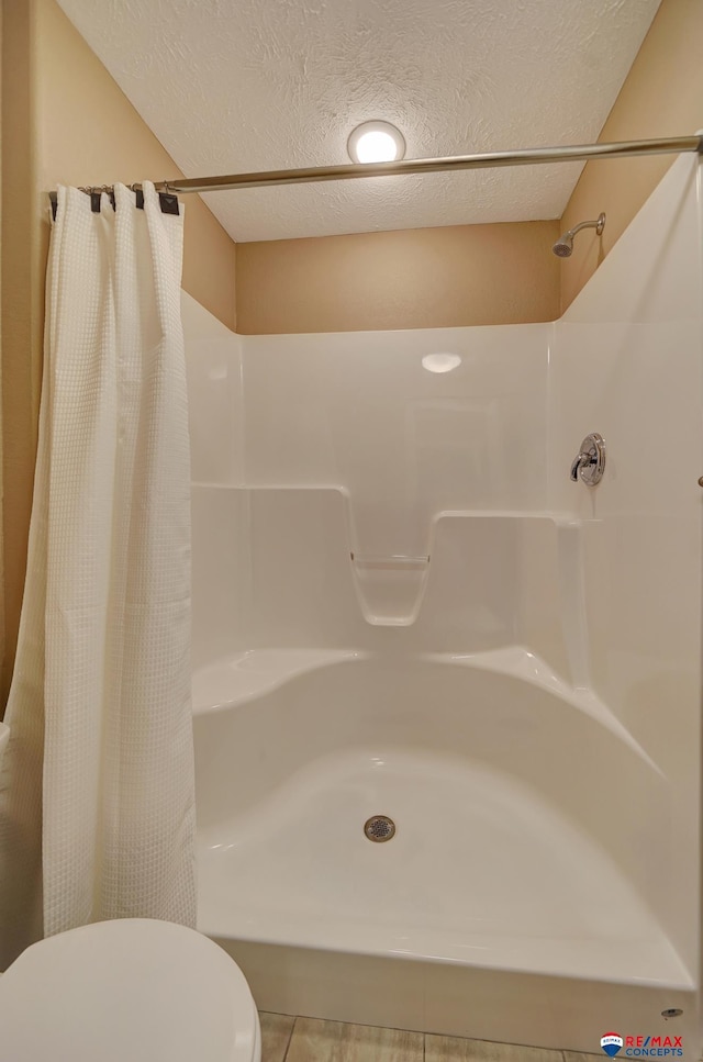 bathroom featuring a textured ceiling and a shower with curtain