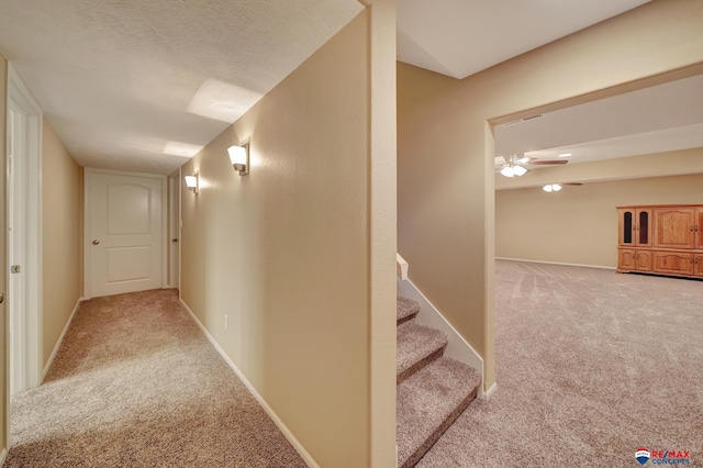 corridor featuring carpet floors and a textured ceiling