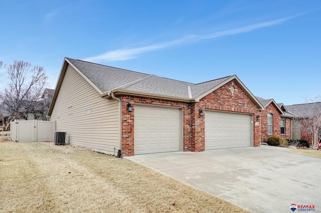 view of front of house featuring cooling unit, a garage, and a front yard