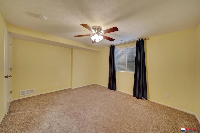 carpeted empty room with ceiling fan and a textured ceiling